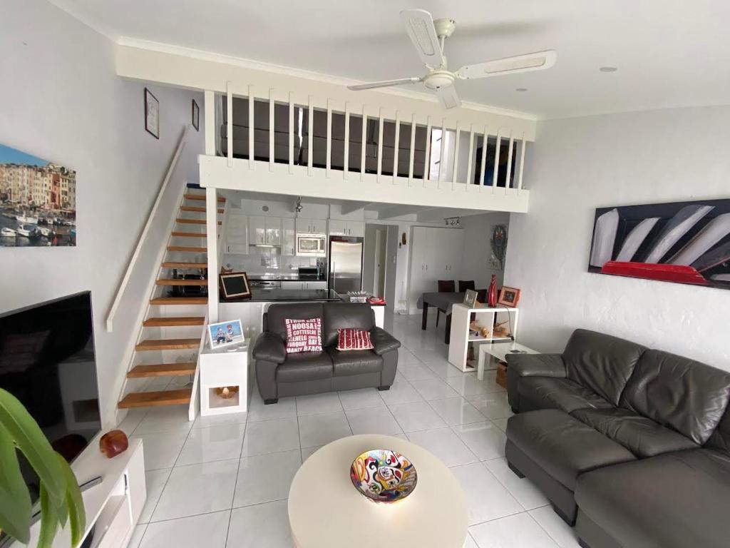 a living room with a couch and a staircase at Port Lincoln Marina Waterfront Apartment in Port Lincoln