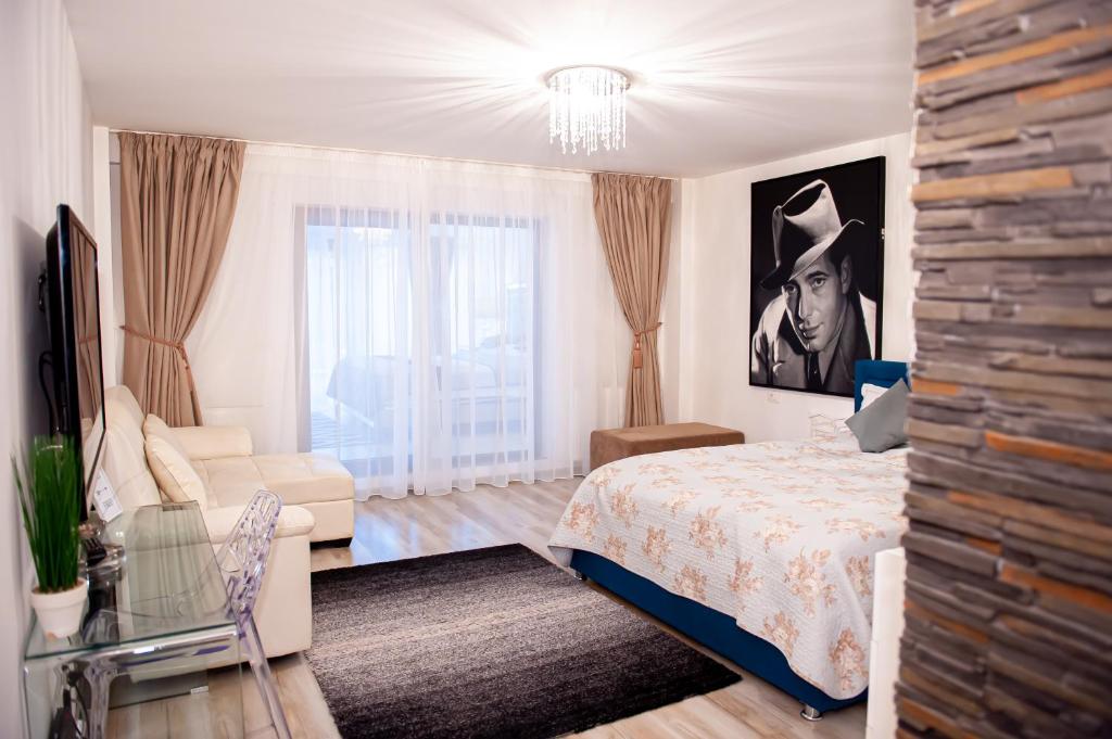 a bedroom with a bed and a couch at Kai Mountain Luxury Apartment in Braşov