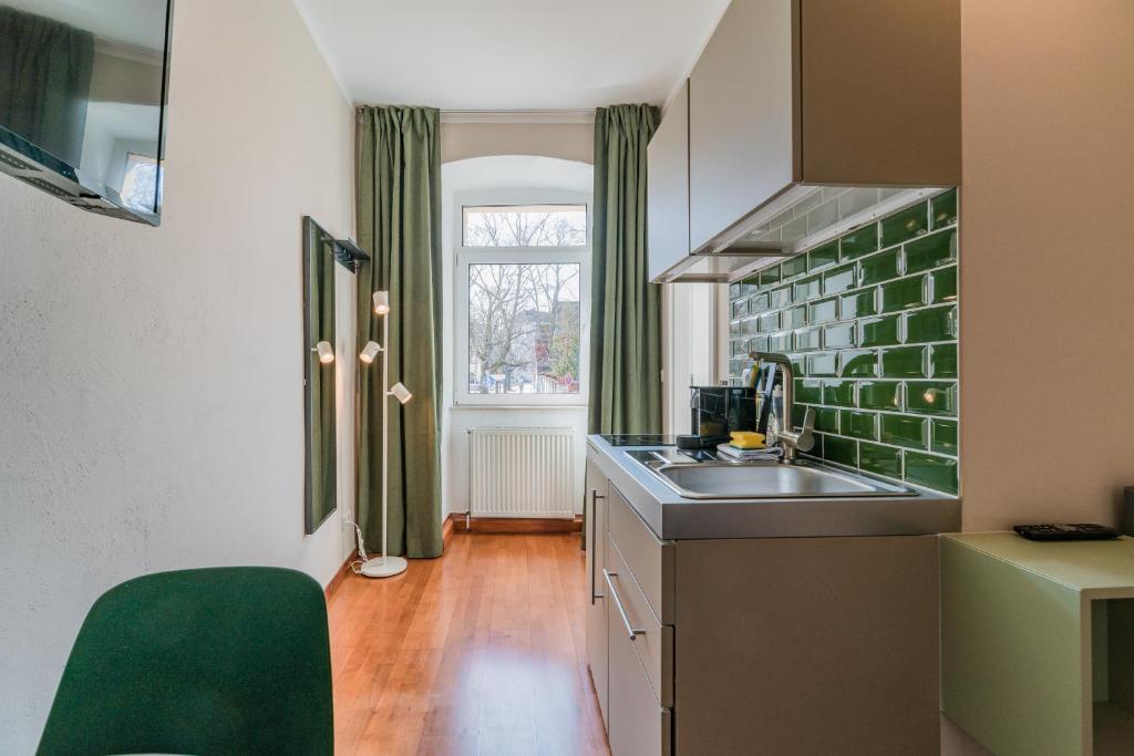 a small kitchen with a sink and a window at SUITE & APART in Berlin