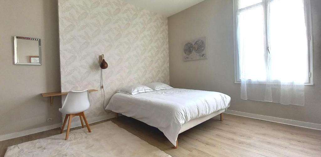a bedroom with a white bed and a window at Histoire de Loire - DU BELLAY in Saumur