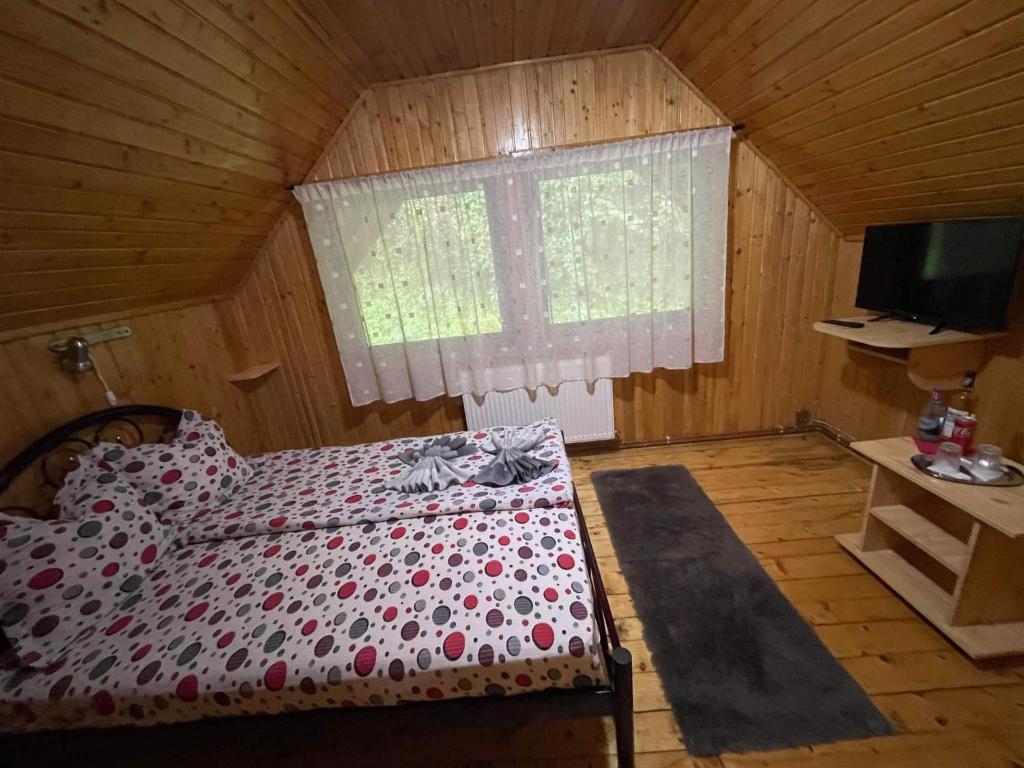 1 dormitorio con 1 cama en una habitación con ventana en Vila Maria Dambovicioara, en Dîmbovicioara
