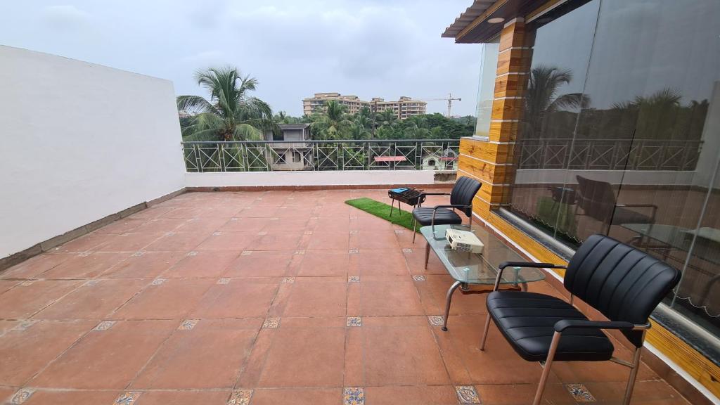a patio with chairs and tables on a balcony at RK 2 and 3 bedroom penthouse in Panaji