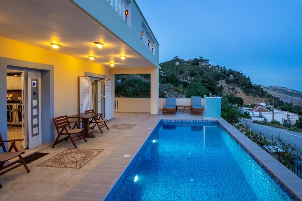 a villa with a swimming pool at night at Karpathos View Villa in Karpathos