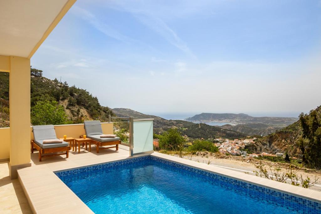 a villa with a swimming pool and a table and chairs at Karpathos View Villa in Karpathos