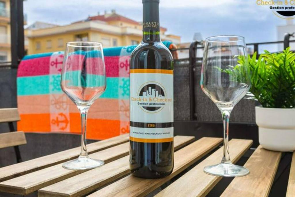 a bottle of wine sitting on a table with two wine glasses at Apartamento El Sherezade 2 Línea Playa, in Fuengirola