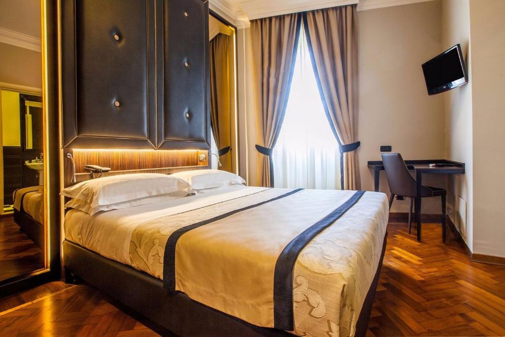 a hotel room with a bed and two lamps at Hotel Lombardia in Florence
