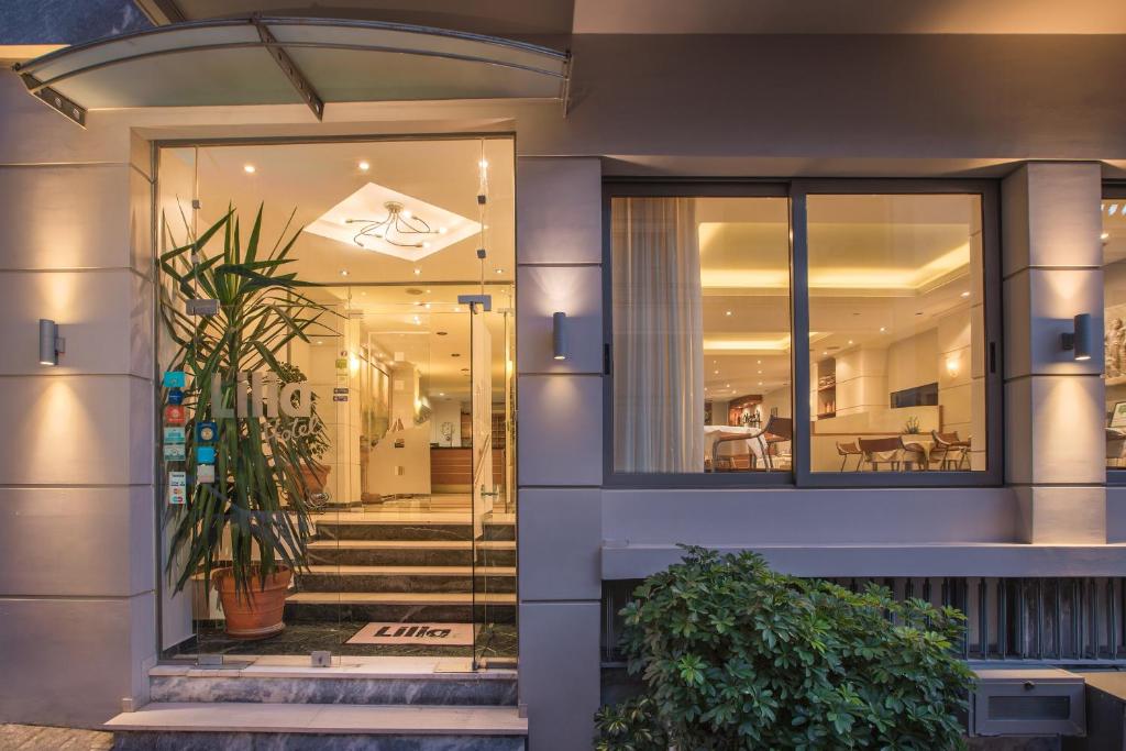 drzwi wejściowe budynku ze schodami i roślinami w obiekcie Lilia Hotel w Pireusie