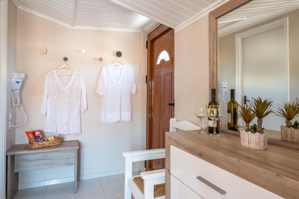 a dressing room with a white shirt hanging on a wall at Esperides Studios in Syvota