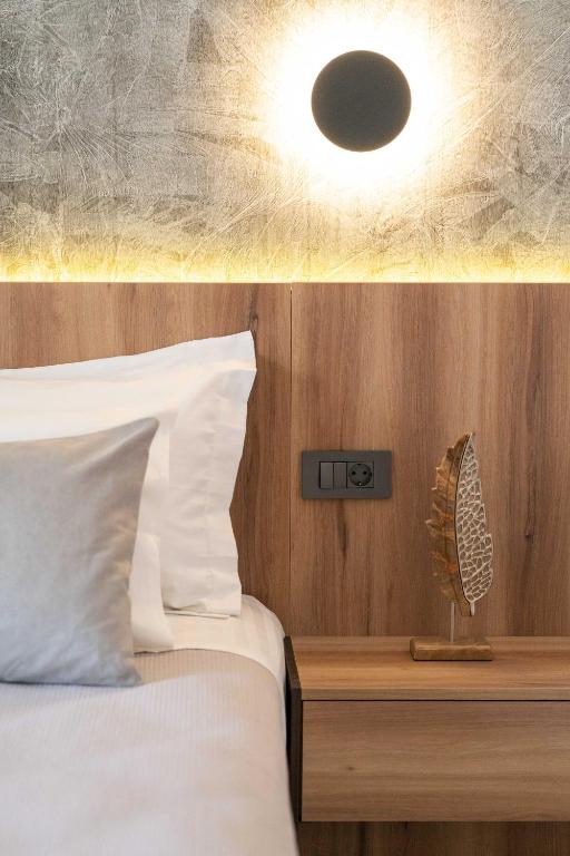 a bedroom with a bed and a light on the wall at Esperides Studios in Syvota