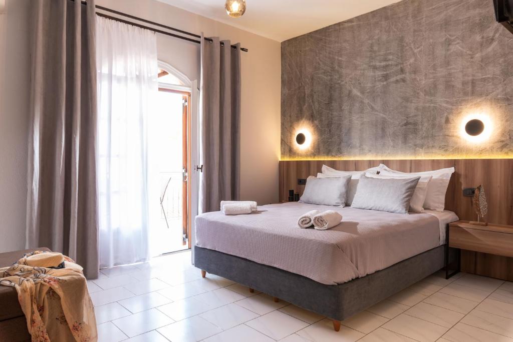 a bedroom with a large bed and a large window at Esperides Studios in Syvota