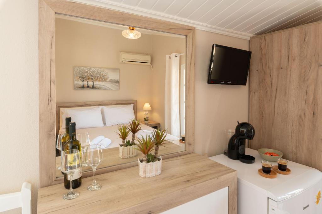 a bedroom with a bed and a large mirror at Esperides Studios in Syvota