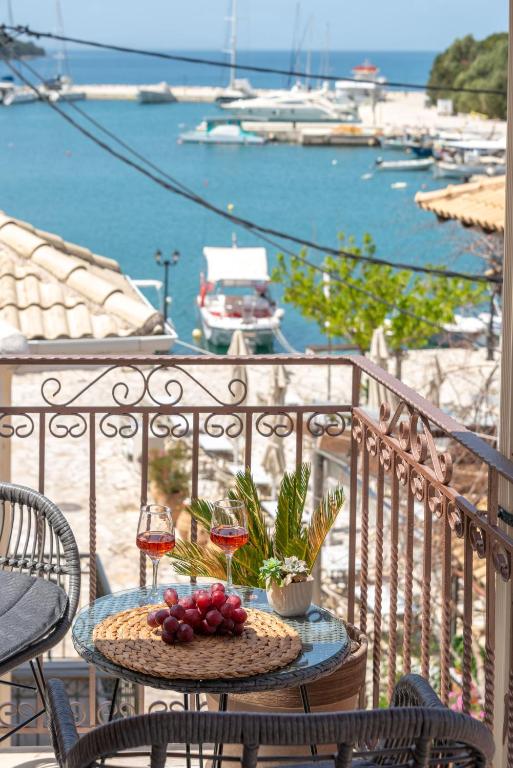 a table with fruit and wine glasses on a balcony at Esperides Studios in Syvota