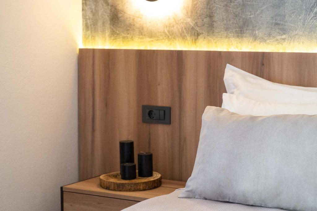 a bed with a pillow and two candles on a night stand at Esperides Studios in Syvota