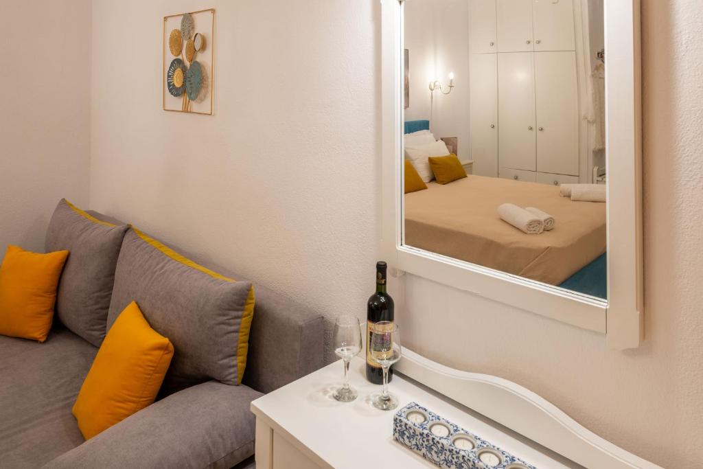 a living room with a couch and a mirror at Esperides Studios in Syvota