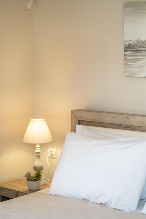 a bedroom with a white bed and a lamp at Esperides Studios in Syvota