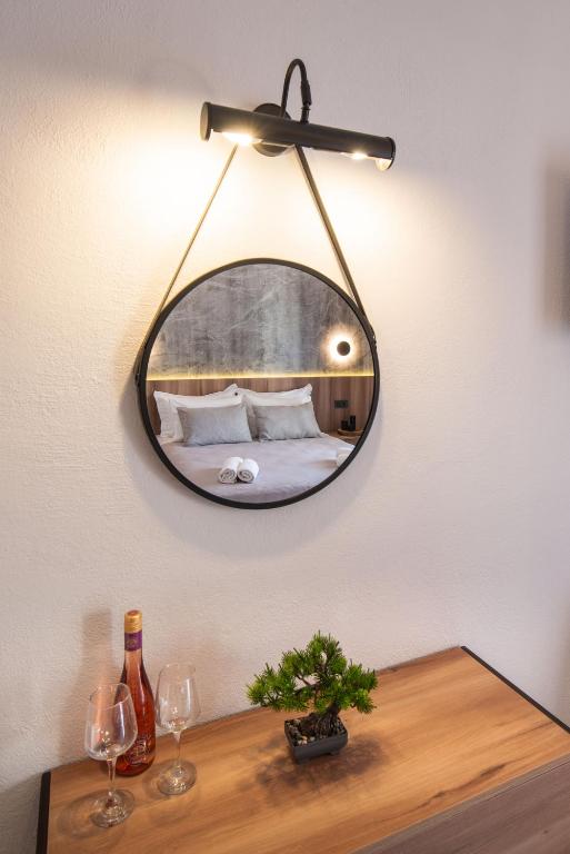 a mirror on a wall above a table with wine glasses at Esperides Studios in Syvota