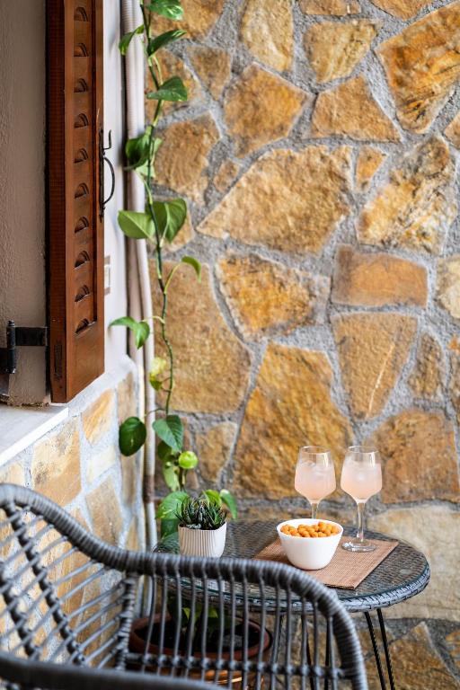 a table with two wine glasses on a patio at Esperides Studios in Syvota