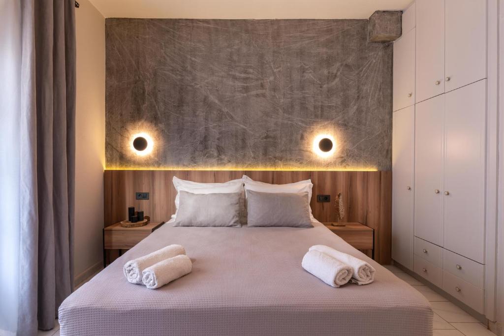a bedroom with a large bed with two towels on it at Esperides Studios in Syvota