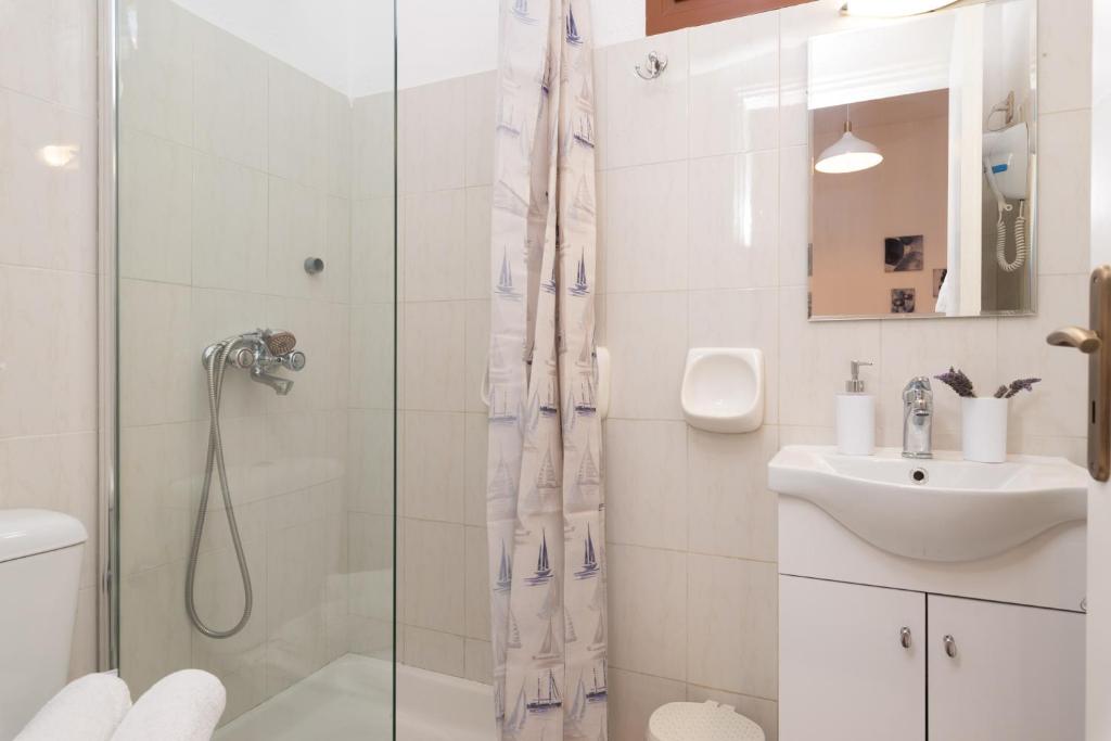 a bathroom with a shower and a sink at Esperides Studios in Syvota