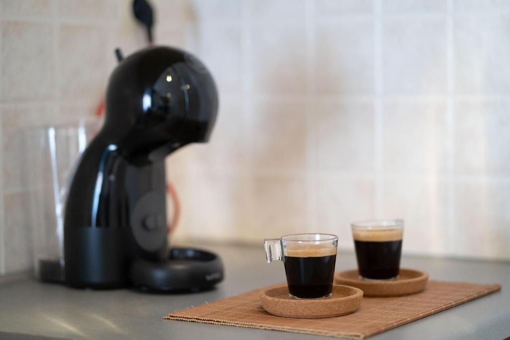 two cups of coffee sitting on a cutting board at Esperides Studios in Syvota