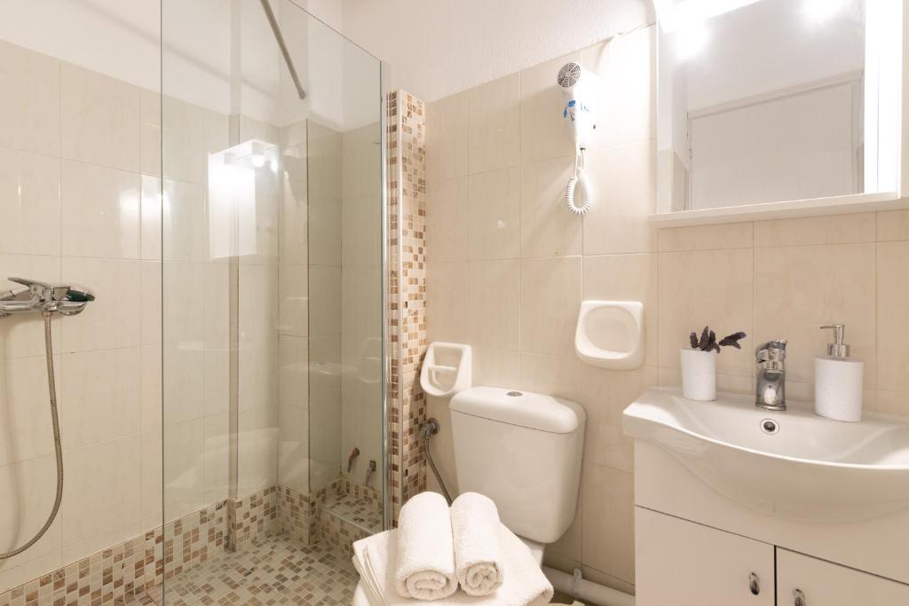 a bathroom with a shower and a toilet and a sink at Esperides Studios in Syvota