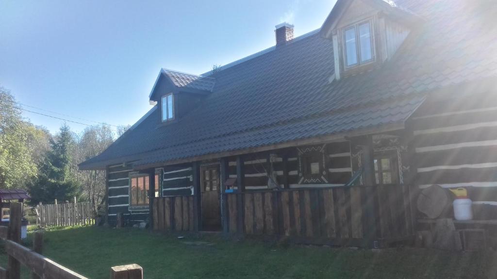 a large wooden house with a fence in front of it at Horpyna in Krempna