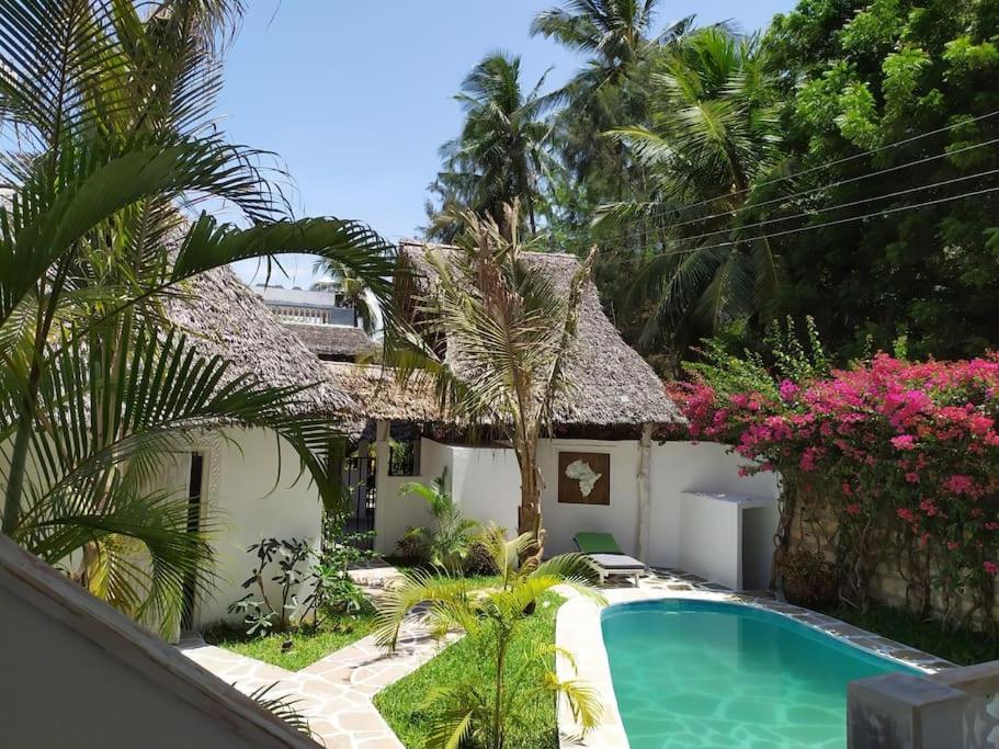 a villa with a swimming pool and a resort at Garoda House Turtle Bay [ Jacuzzi ☆☆☆☆☆ ] Kilifi in Watamu