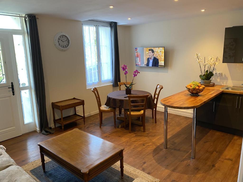 une cuisine et un salon avec une table et des chaises dans l'établissement autour de la rose, à Honfleur