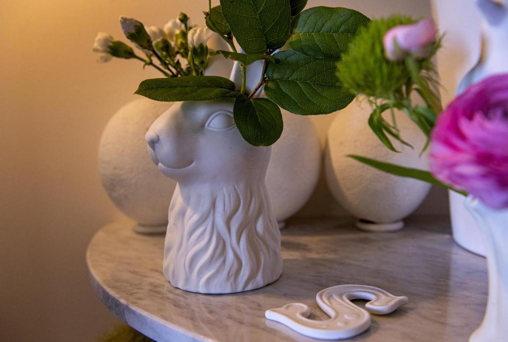 a vase with a snake on a table with flowers at B&B La Locandiera in Castiglione della Pescaia