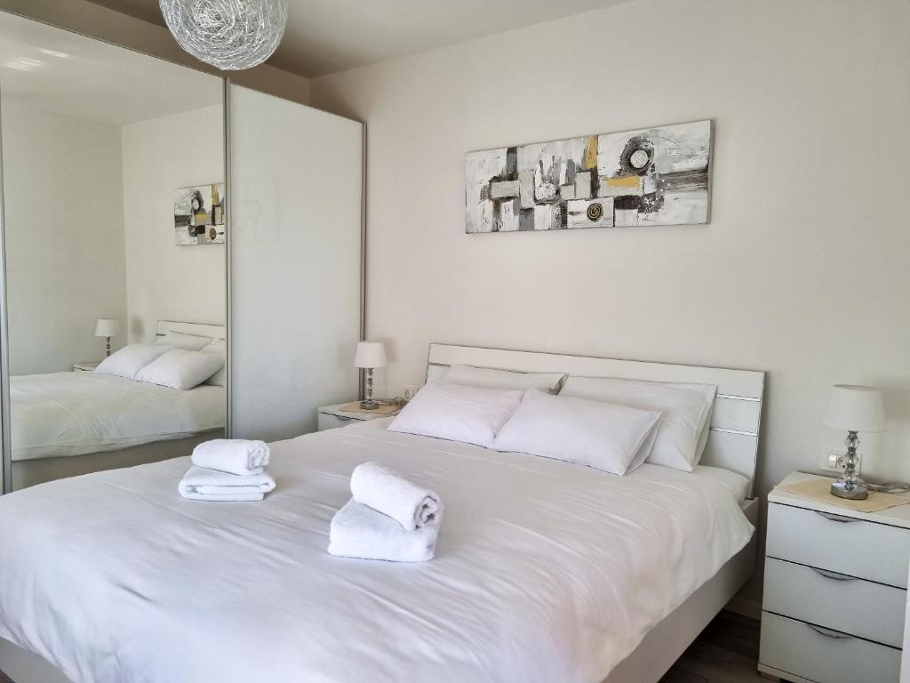 ein weißes Schlafzimmer mit zwei weißen Handtüchern auf einem Bett in der Unterkunft Juli No 2 in Poreč