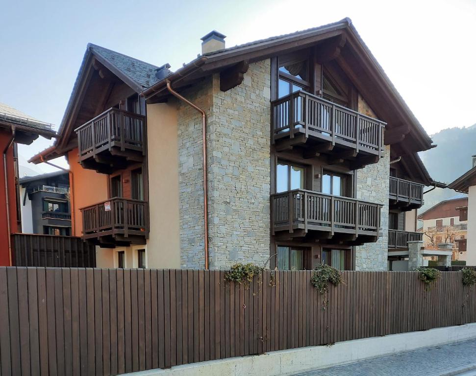 a building with balconies and a wooden fence at Olympic Chalet in Bormio