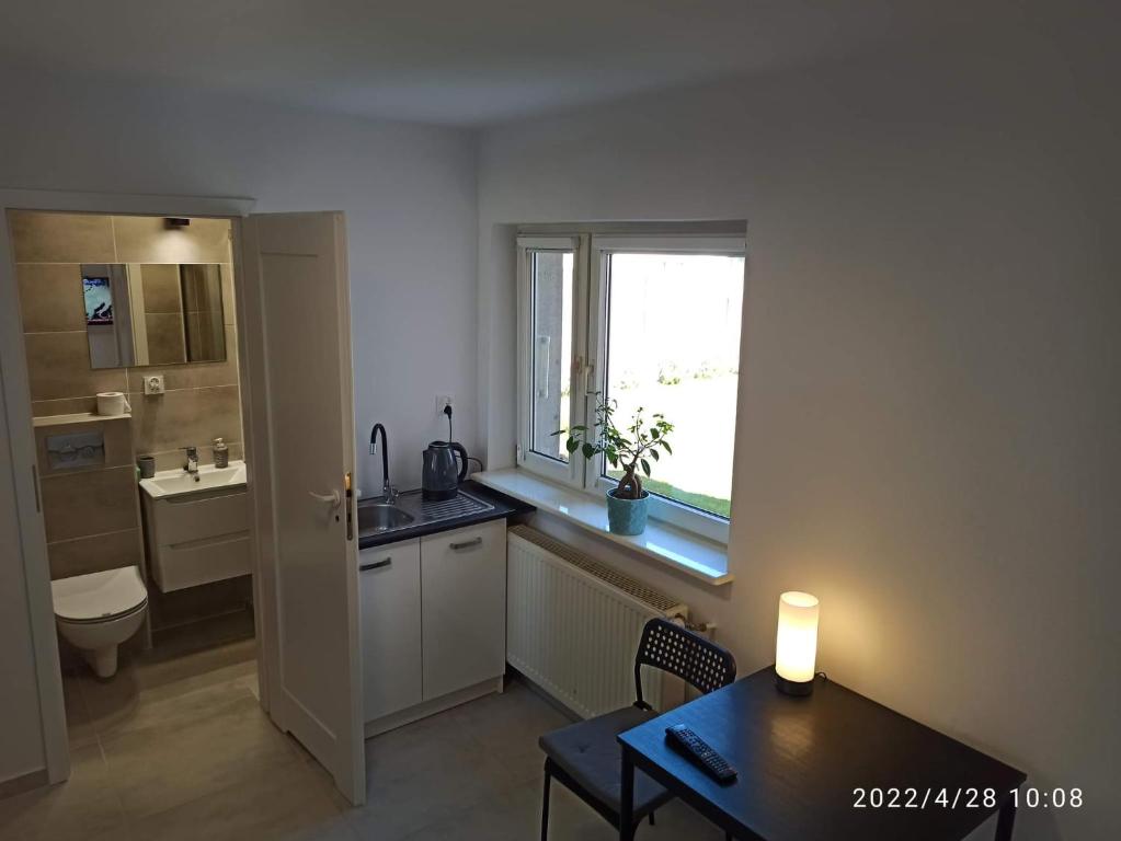 a kitchen with a table and a sink and a window at Krynica - pokoje in Krynica Morska