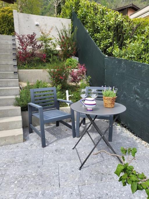 un patio con tavolo, panca, tavolo e sedia di Al Ronchetto a Riva San Vitale