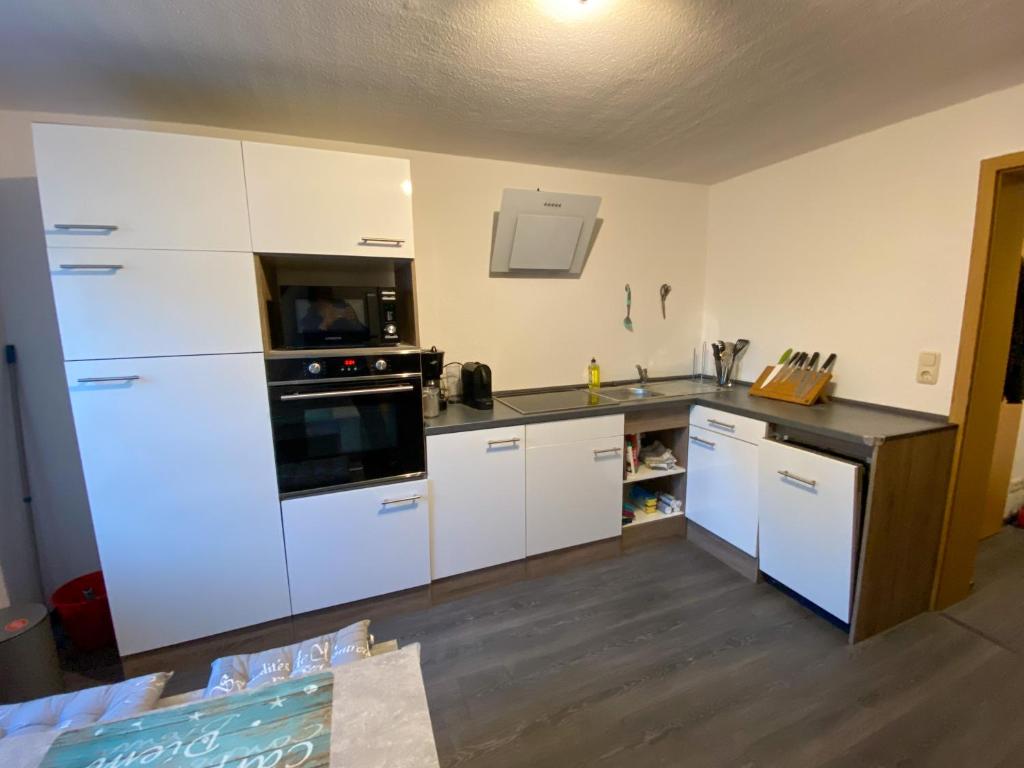 a kitchen with white cabinets and a stove top oven at Ferienwohnung zum Pinguin 3 in Wiednitz