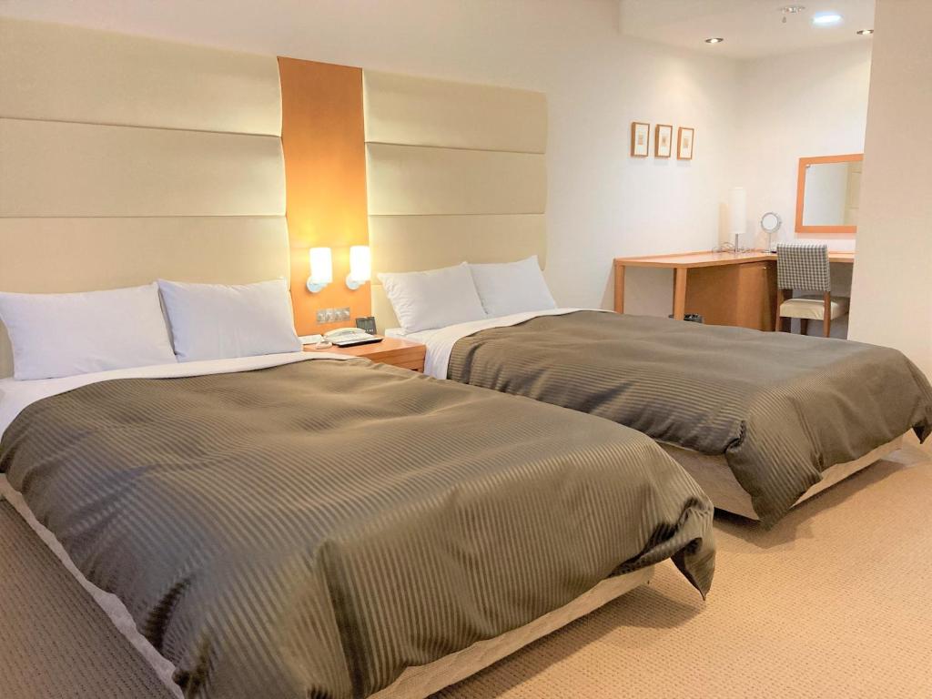 Postel nebo postele na pokoji v ubytování Tabist Hotel Colosseum Inn Tateshina