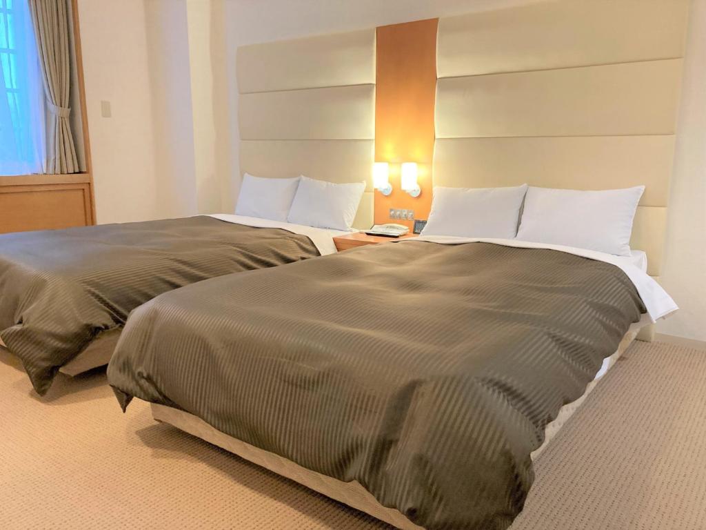 Postel nebo postele na pokoji v ubytování Tabist Hotel Colosseum Inn Tateshina
