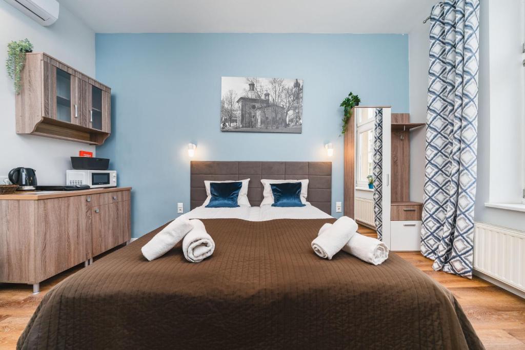 een slaapkamer met een groot bed met blauwe muren bij Grace Apartments in Krakau