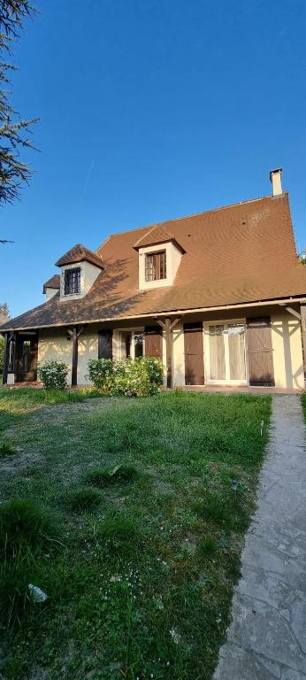 une maison avec un toit marron et une cour d'herbe dans l'établissement La Villa Jacuzzi et Cinéma 