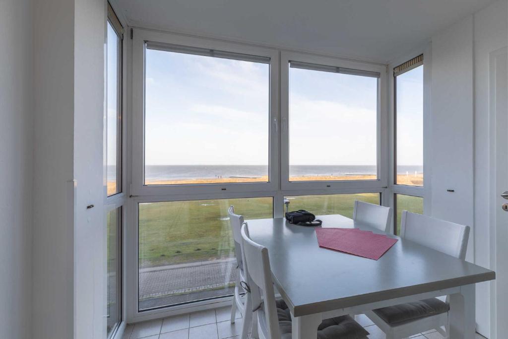 einen Tisch und Stühle vor einem Fenster in der Unterkunft Ferienwohnung 8 im Haus Horizont in Cuxhaven