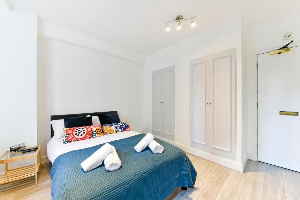 a bedroom with a bed with towels on it at South Kensington Studio in London
