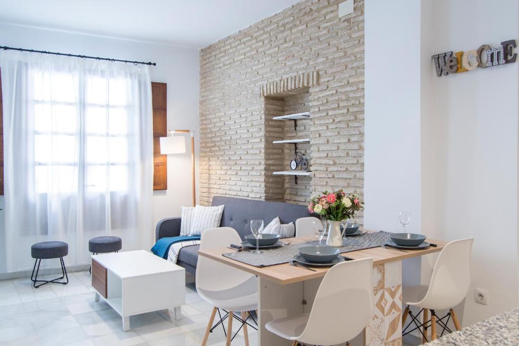 uma sala de jantar e sala de estar com mesa e cadeiras em Riverside Triana Apartment em Sevilha