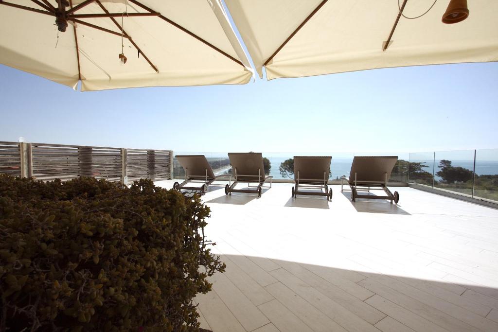 eine Sitzgruppe auf einer Terrasse mit einem Sonnenschirm in der Unterkunft Villa Mareblu - Ansedonia in Ansedónia