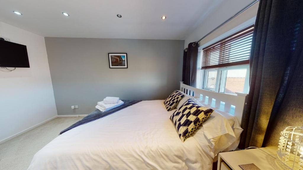 a bedroom with a bed with pillows and a window at Victoria House in Hull