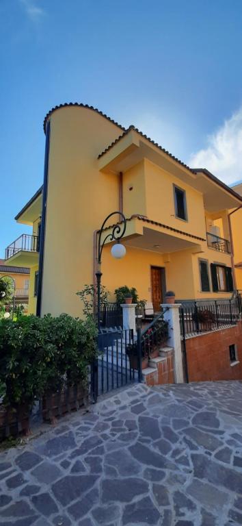 a yellow building with a black fence in front of it at Anagnina Apartment Capistrano in Rome