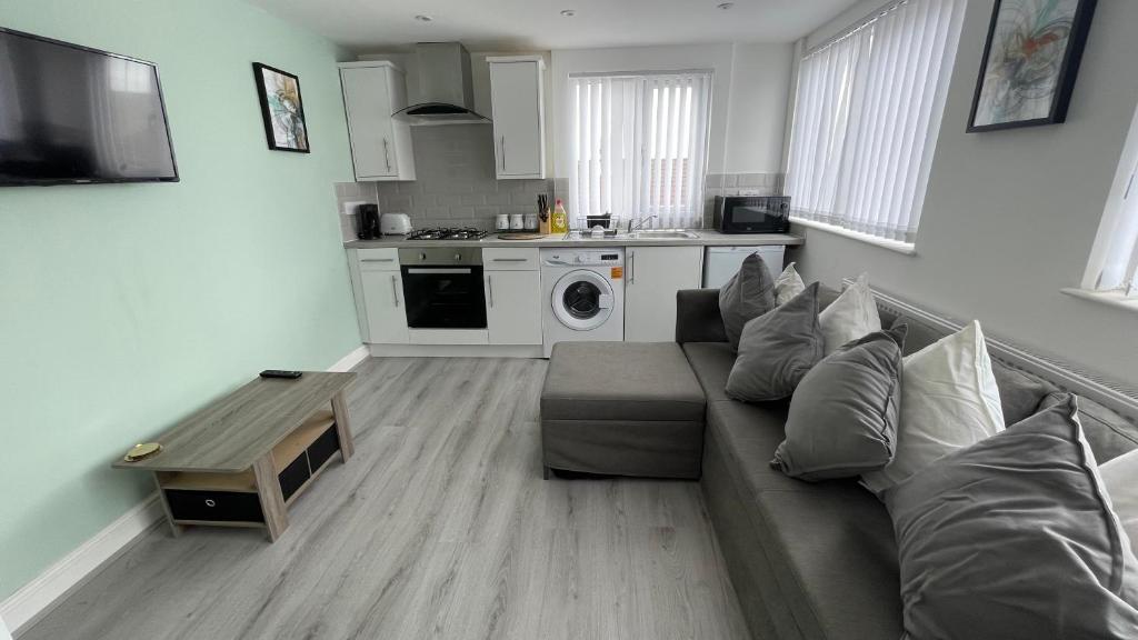 a living room with a couch and a kitchen at Hosted By Ryan - Anfield Apartments in Liverpool