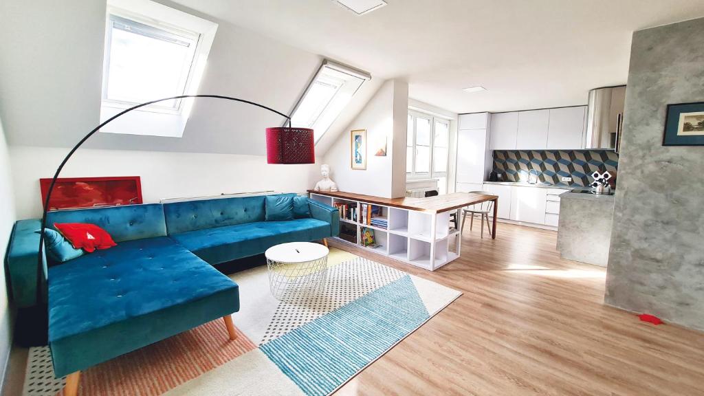 un soggiorno con divano blu e una cucina di Apartmán Polygon a Valtice