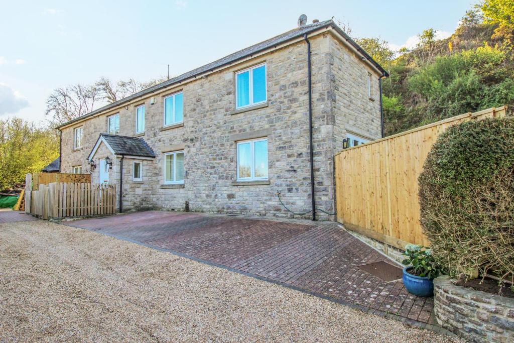 una casa de ladrillo con una valla de madera delante de ella en Corfe Lodge, en Corfe Castle