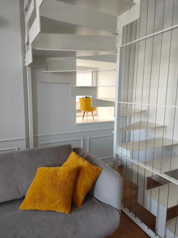 a living room with a gray couch and a yellow pillow at La Maison du Quai Triplex de charme 4 étoiles en hyper centre avec SPA in Landerneau