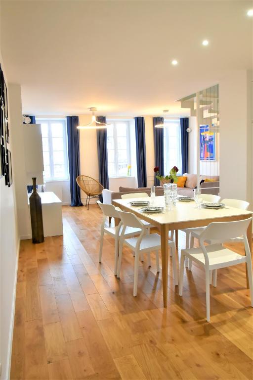 a dining room with a white table and chairs at La Maison du Quai Triplex de charme 4 étoiles en hyper centre avec SPA in Landerneau