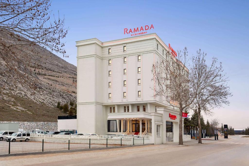 a white building with a sign on top of it at Ramada By Wyndham Elbistan in Elbistan